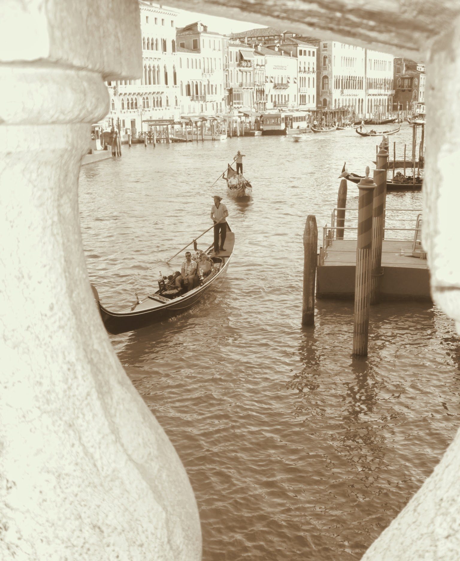 A gondola on a Venice canal, framed by a stone balustrade