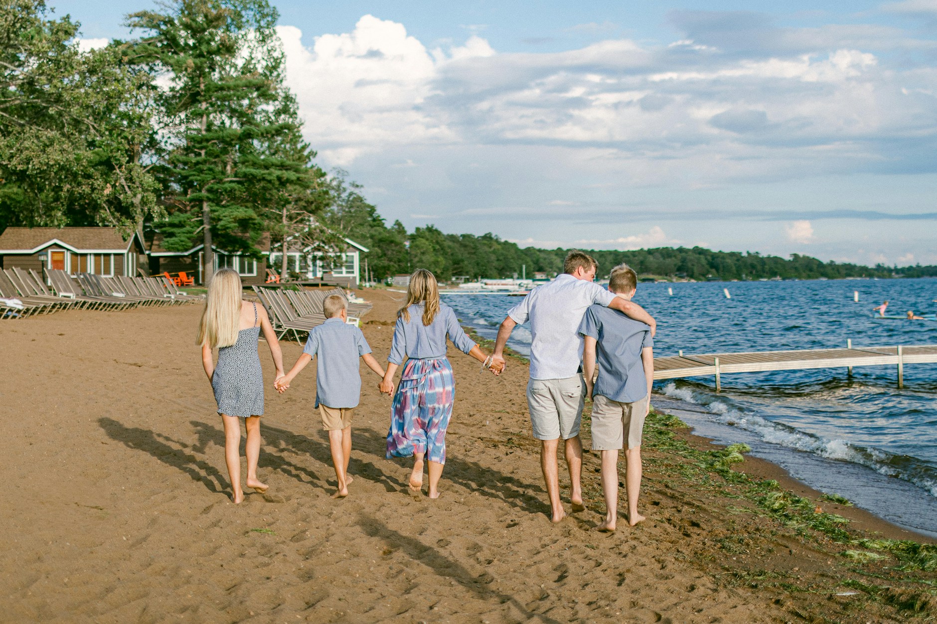 A family walking hand in hand along the shore