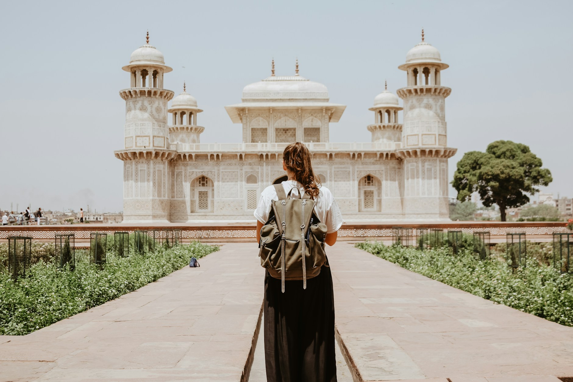 A traveler walking toward a white marble monument